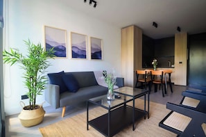 Experience modern comfort in this stylish living space, featuring elegant decor and a cozy dining area, perfect for relaxation and gatherings.