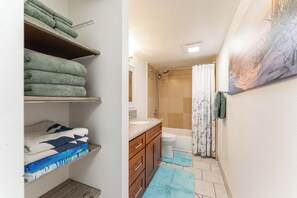Fresh, fully stocked bathroom with plush towels, granite vanity, and a relaxing tub-shower combo.