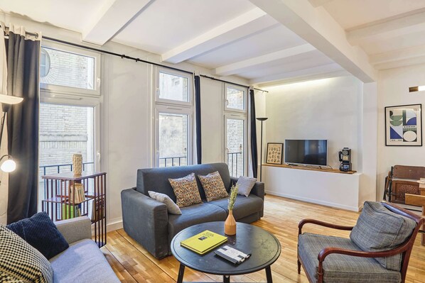 Salon avec table basse, TV et espace repas