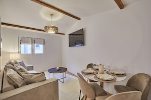Salon avec coin repas et télévision