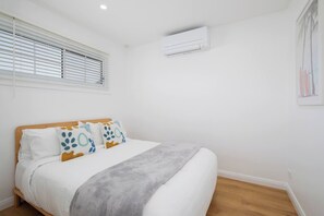 Relax in the primary bedroom with a queen bed dressed in soft linen.
