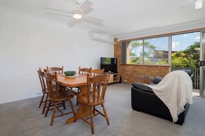 Gather around the timber dining table that seats six, a comfortable spot for shared meals, morning planning sessions, or casual catch-ups over takeaway.