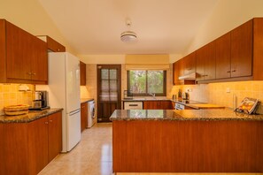 Very spacious kitchen opening up on the living room and dining area makes preparing meals a social and enjoyable part of your stay. The door leads to the kitchen patio.