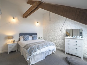 Master bedroom with double bed, carpet and wooden wardrobe.