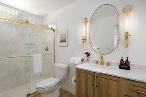 A beautifully renovated bathroom featuring elegant gold accents for a touch of luxury.