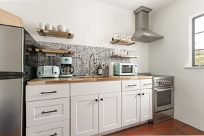 Cook up your favorite meals in a fully equipped kitchen featuring modern appliances and eye-catching tile backsplash.