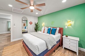 Bedroom Suite 1  with Queen Bed and Dresser Space: Vibrant green walls and plush bedding create a tranquil escape in paradise!

