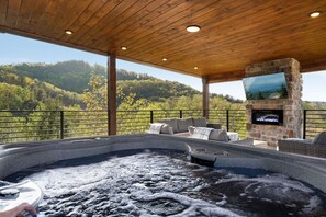 A rooftop deck with views, hot tub, and outdoor dining/living area!