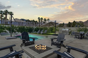 Backyard oasis with firepit, pool, and lounge seating.