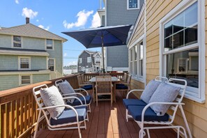 Back deck with plenty of patio furniture and views of the backyard and ocean