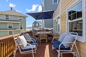 Back deck with plenty of patio furniture and views of the backyard and ocean
