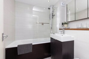 Freshen up after a day at the beach in the light and bright bathroom