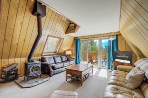 Cozy up in the inviting living area featuring plush seating, a Smart TV, and a wood-burning stove—perfect for relaxing after mountain adventures or enjoying a peaceful evening indoors.








