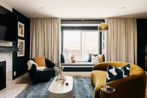 Spacious and elegant living room with comfortable seating, a gas fireplace, and large smart TV