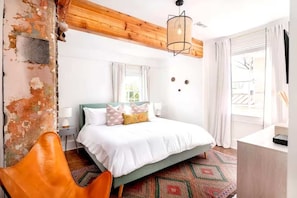 Lounge in a stylish leather butterfly chair and catch up on a good book in this serene bedroom.