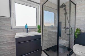 Sleek and stylish bathroom with a modern walk-in shower, chic black fixtures, and plenty of natural light for a refreshing experience.