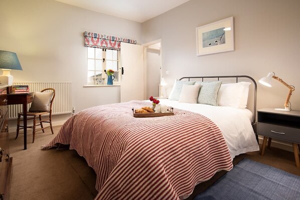 The Bothy at Cheswick - bedroom with a double bed dressed in crisp white linen and dressing table