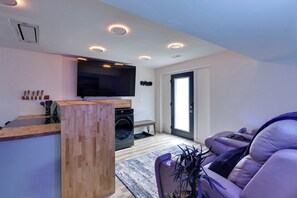 Living Room with TV, Washer, Dryer, and Leather Reclining Sofa