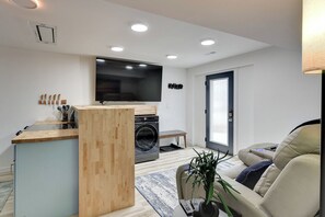 Living Room with TV, Washer, Dryer, and Leather Reclining Sofa
