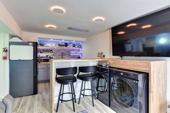 Living Room with TV, Washer, Dryer, and Leather Reclining Sofa