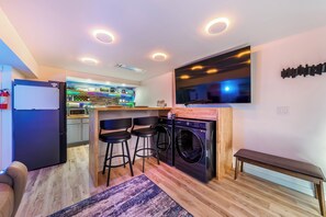 Living Room with TV, Washer, Dryer, and Leather Reclining Sofa