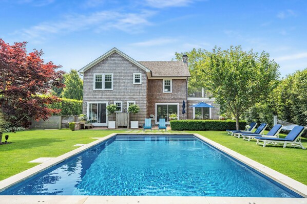 Beautifully landscaped backyard with pool, outdoor shower, & patio
