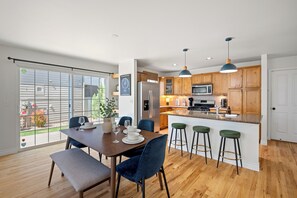 The fully equipped kitchen opens up onto the sleek dining area. You’ll find a charming wooden dining table that comfortably seats six. You’ll love the clean lines,  as well as new furniture and table settings to elevate your dining experience.
