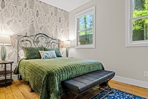 The guest bedroom with queen bed is inspired by a vintage botanical theme.