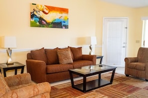 The inviting living area, adorned with comfortable seating and vibrant decor, is perfect for relaxing and enjoying quality time with family or friends.