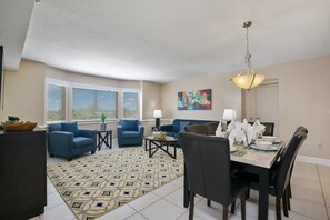 Experience dining and relaxation in an open living and dining area, complete with tasteful decor, a fully equipped kitchen, and a comfortable seating arrangement.