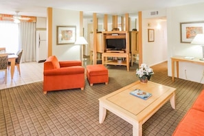This stylishly designed living space features vibrant colors and an open layout, complete with a fully equipped kitchen and access to outdoor views for a serene stay.