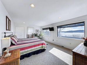 Wake up to river views from this king bedroom—your serene retreat after a day of outdoor adventure.