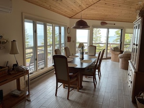 Dining area with large windows and vaulted ceilings, blending indoor comfort with outdoor beauty.