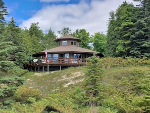 Custom octagon home perched above the dunes, offering panoramic views of Lake Michigan and total privacy on 12 wooded acres.