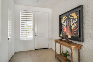 Stylish entryway welcomes you with vibrant art and warm natural light.