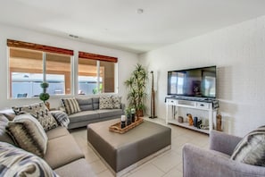 Bright and inviting living space with plush seating and a large smart TV—your home away from home.