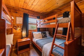 The guest room features two bunk beds: one twin-over-twin and one twin-over-full, offering cozy sleeping space for up to five.