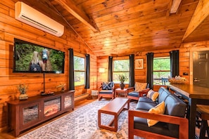 Relax in the inviting living room with a 55" smart TV, plush seating, and an electric fireplace for cozy evenings in.
