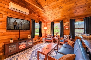Relax in the inviting living room with a 55" smart TV, plush seating, and an electric fireplace for cozy evenings in.