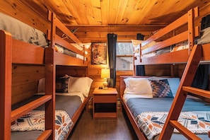 The guest room features two bunk beds: one twin-over-twin and one twin-over-full, offering cozy sleeping space for up to five.