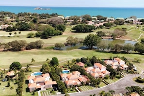 Drone view of the house (on the Cul de Sac, last one on the right) with views of the golf course and ocean beyond. The house comes with a golf cart to take you to the private beach club with restaurant and huge community pool.