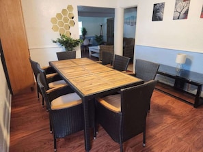 Bright dining area with a large wooden table and six black chairs, perfect for meals or meetings