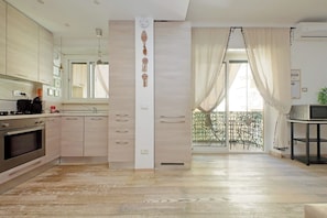 Integrated living and kitchen spaces in an open layout with direct access to a private balcony.