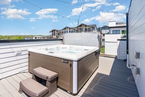 Rooftop deck with a hot tub, outdoor dining for 6, and cozy lounge seating—perfect for unwinding.