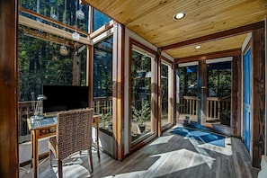 A peaceful nook to work, where the forest greets you through every window.