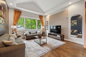 Living Room: Unwind on comfy couches, framed by striking Art Deco wallpaper and retro vinyl art. Style meets comfort in every corner.