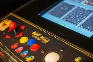 Have fun in the game room with a classic Pac-Man arcade machine, perfect for nostalgic entertainment and friendly competition.