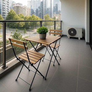 Enjoy a cozy balcony retreat with city views, perfect for morning coffee or evening relaxation.