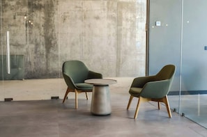 Relax in this stylish living space featuring modern furnishings and a sleek concrete backdrop, perfect for unwinding after a day of adventure.