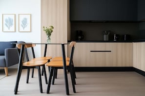 Experience modern living in this stylish kitchen, featuring a sleek glass dining table and elegant decor for a perfect dining experience.